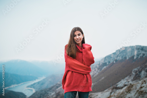 Beautiful Young Girl in a cosy red sweater on Mountain top