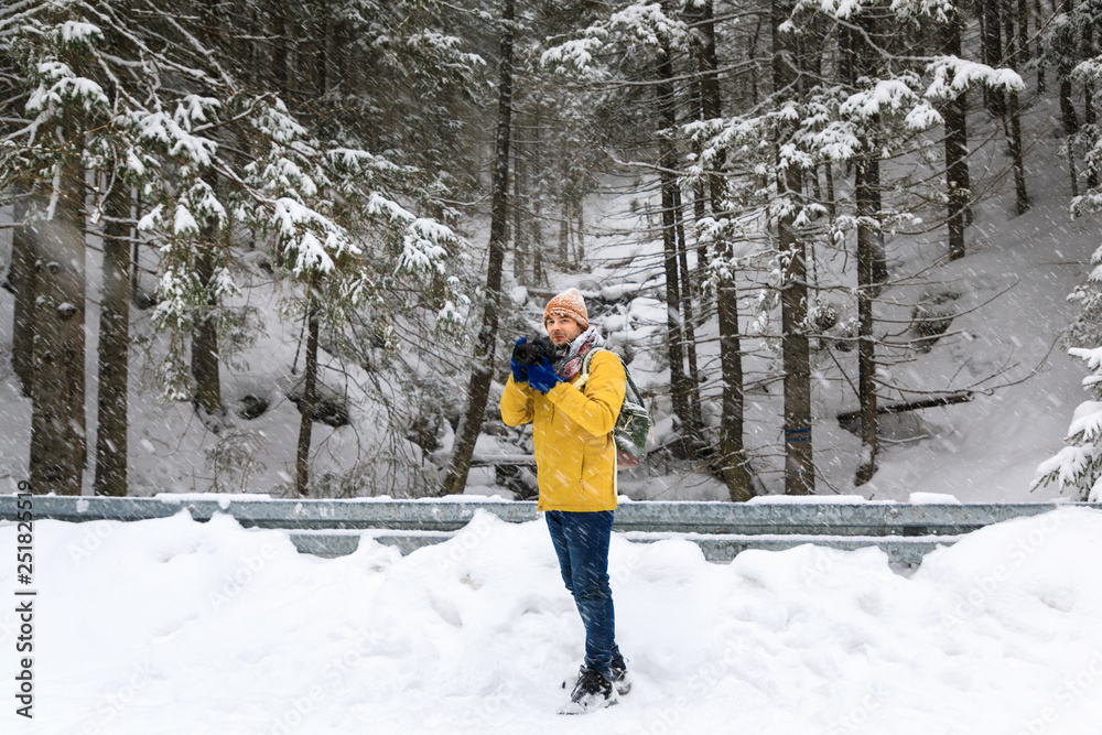 The photographer in winter forest in mountains