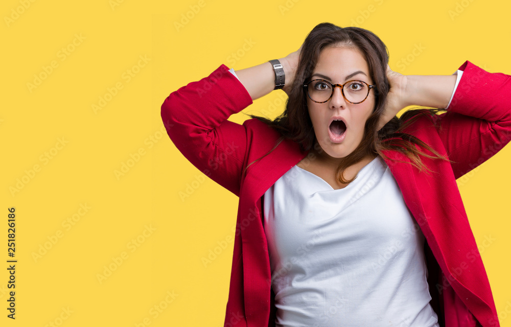 Beautiful plus size young business woman wearing elegant jacket and glasses over isolated background Crazy and scared with hands on head, afraid and surprised of shock with open mouth Beautiful plus size young business woman wearing elegant jacket and glasses over isolated background Crazy and scared with hands on head, afraid and surprised of shock with open mouth