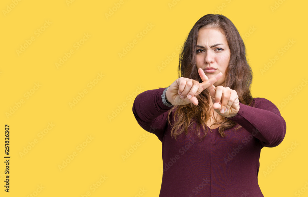 Beautiful and attractive plus size young woman wearing a dress over isolated background Rejection expression crossing fingers doing negative sign Beautiful and attractive plus size young woman wearing a dress over isolated background Rejection expression crossing fingers doing negative sign