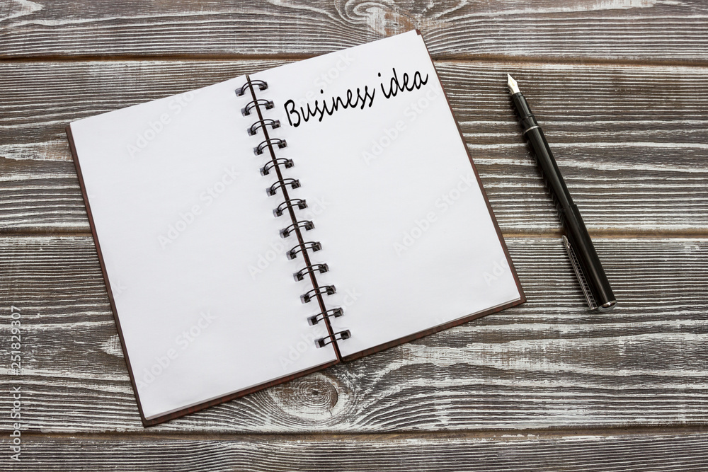 Business ideas written on a notebook, pen on a wooden table background. the concept of business planning. Business ideas written on a notebook, pen on a wooden table background. the concept of business planning.