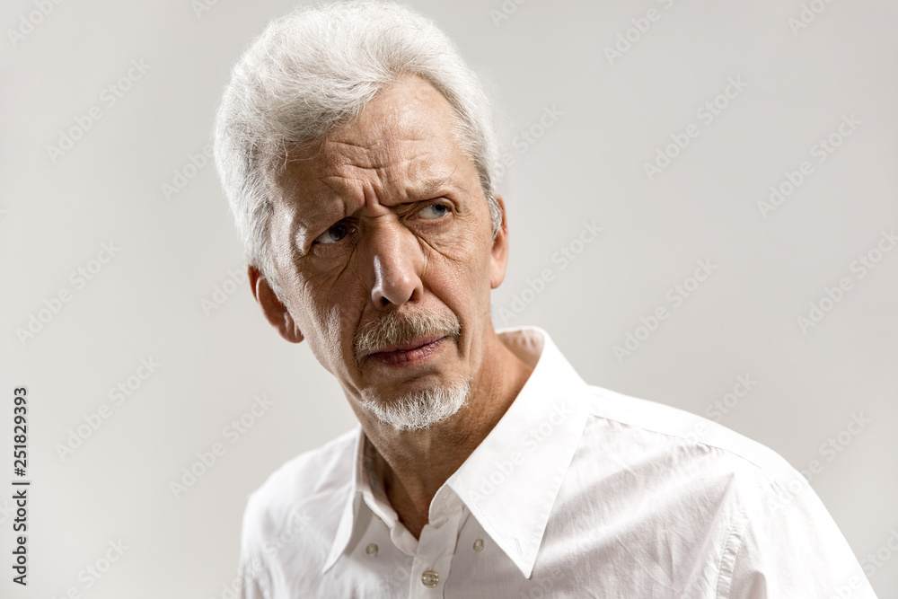 Serious businessman standing, looking at camera isolated on gray studio background. Male half-length portrait. Human emotions, facial expression concept. Serious businessman standing, looking at camera isolated on gray studio background. Male half-length portrait. Human emotions, facial expression concept.