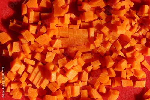 Food Background. Finely Chopped Carrot Over Red Background. Fresh Carrot.
