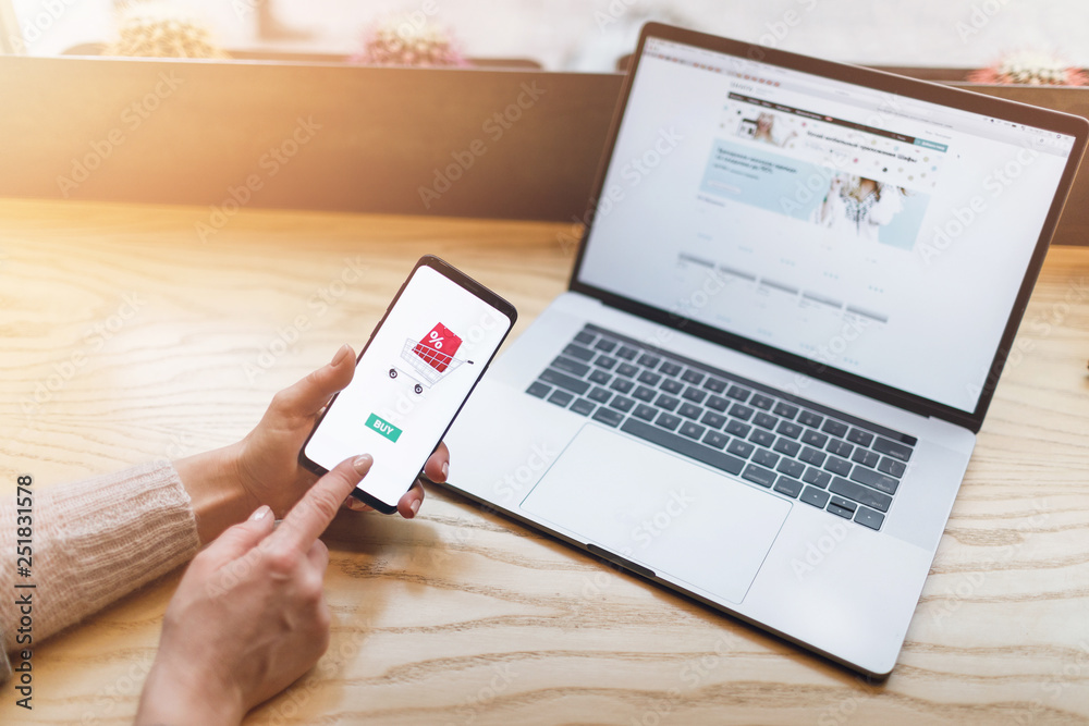 Fototapeta premium Girl doing e-shopping. Online payment, Hands holding smartphone.