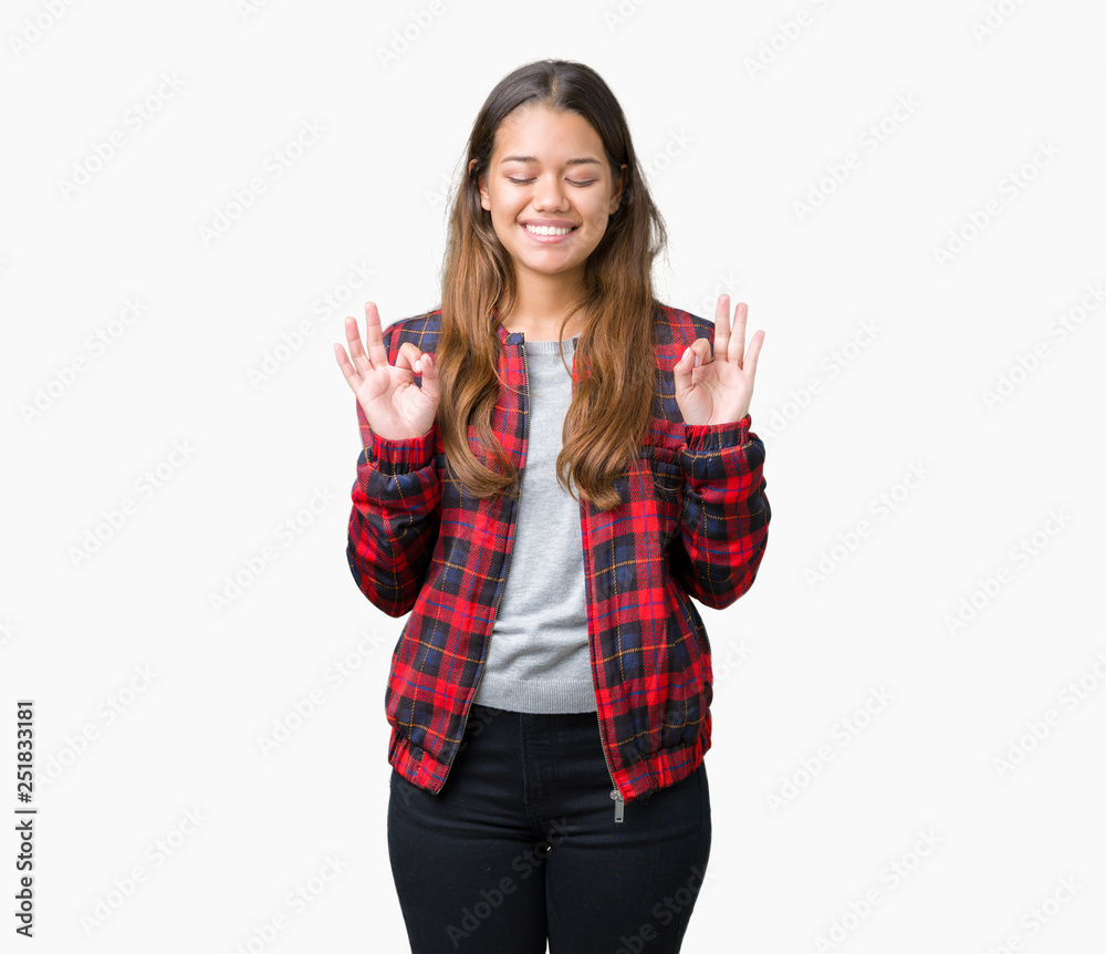 Young beautiful brunette woman wearing a jacket over isolated background relax and smiling with eyes closed doing meditation gesture with fingers. Yoga concept. Young beautiful brunette woman wearing a jacket over isolated background relax and smiling with eyes closed doing meditation gesture with fingers. Yoga concept.