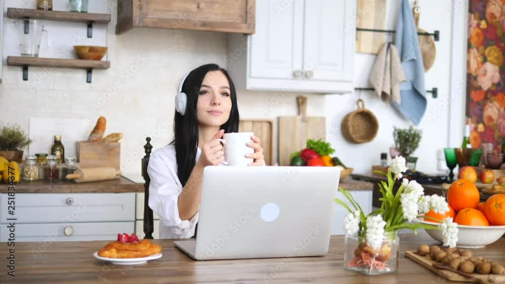 Student Girl Wearing Headphones Working On Laptop And Drinking Coffee At Home Student Girl Wearing Headphones Working On Laptop And Drinking Coffee At Home
