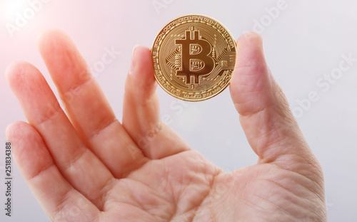 Golden Bitcoin holding in man s hand on white background