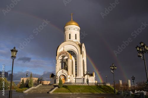 Christian Church temple is the Cathedral in background of rainbow and cloudy sky with storm clouds monument of Russian spiritual and religious architectural tradition and Orthodoxy.