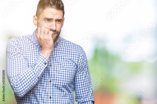 Young handsome man over isolated background looking stressed and nervous with hands on mouth biting nails. Anxiety problem.