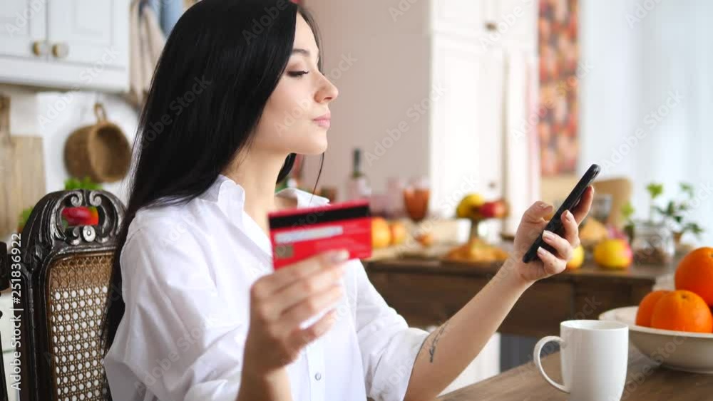 Online Payment Services Concept. Young Woman Using Smartphone And Credit Card At Home. Online Payment Services Concept. Young Woman Using Smartphone And Credit Card At Home.