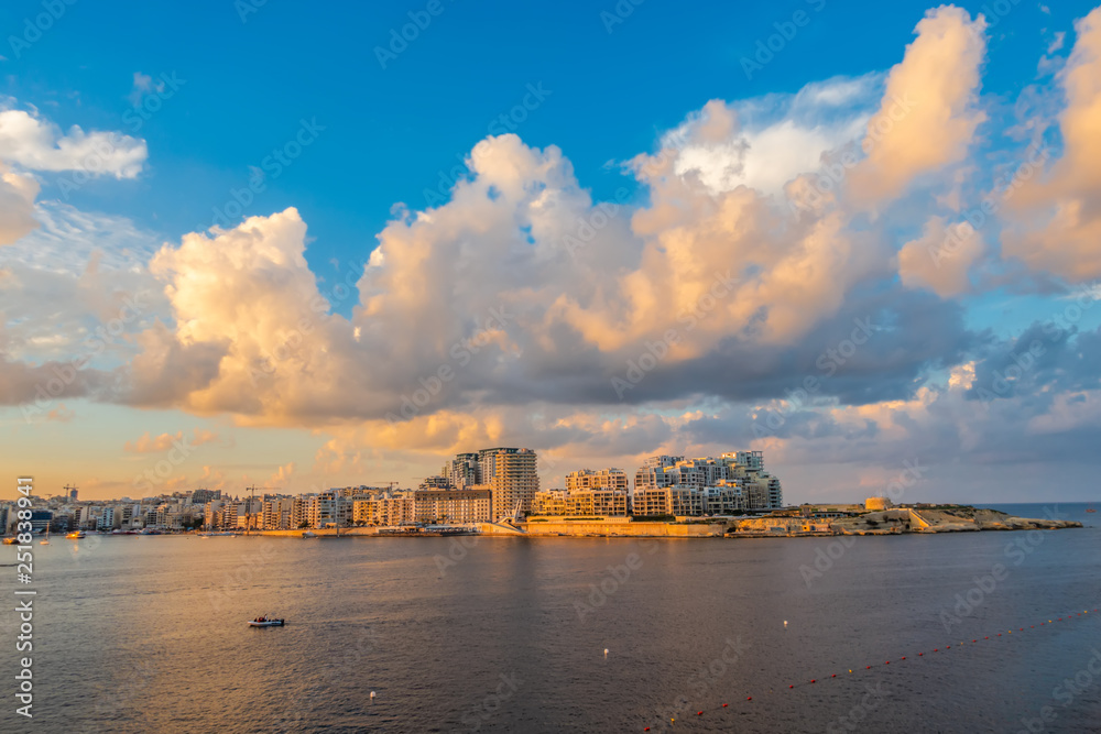 beautiful view of european city Sliema with seafront and blue sky with clouds in sunset, Malta