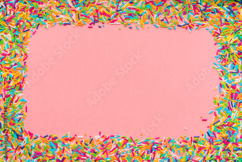 greeting wreath of colorful sprinkles over pink background, festive invitation for Valentines day, birthday, holiday and party time