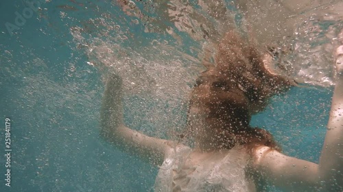 Girl in a white lace dress under water