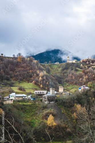 Panoramic view of small town placed on green hills of mountain valley in clouds  Svaneti 