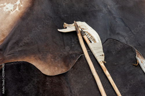 Wooden spear and an axe made of an animal jaw bone photo