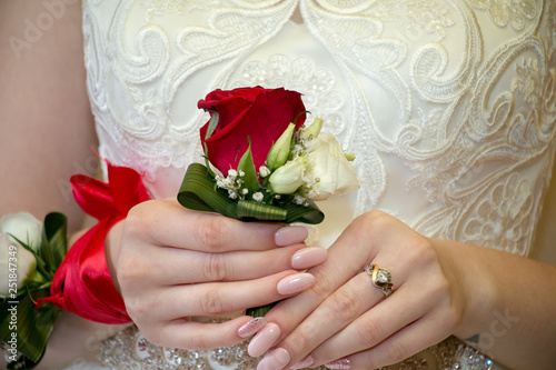 Wedding bouquet in the hands of the bride. Wedding boutonier. Bouquet of red roses photo