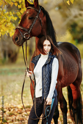 Woman with her horse at sunset, autumn outdoors scene