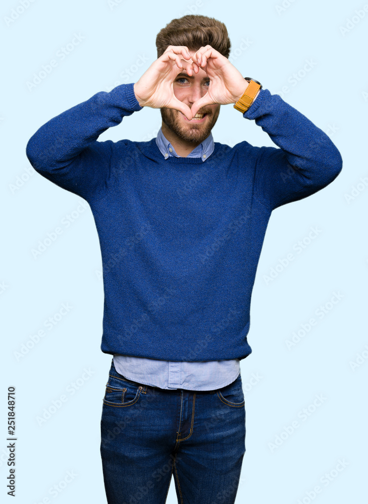 Young handsome bussines man Doing heart shape with hand and fingers smiling looking through sign Young handsome bussines man Doing heart shape with hand and fingers smiling looking through sign