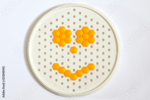 Yellow smiley from mosaic on a white background