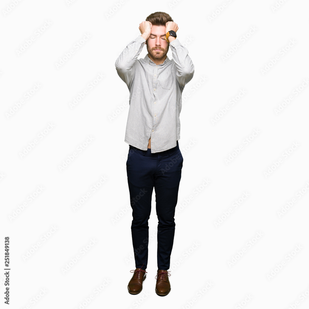 Young handsome man wearing casual shirt suffering from headache desperate and stressed because pain and migraine. Hands on head. Young handsome man wearing casual shirt suffering from headache desperate and stressed because pain and migraine. Hands on head.