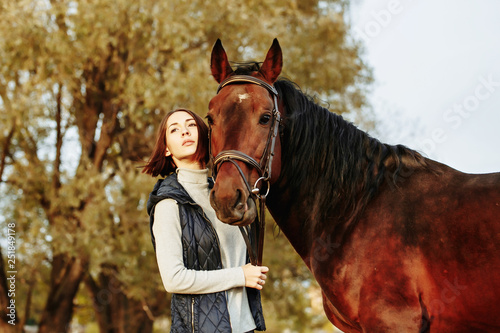 Woman with her horse at sunset, autumn outdoors scene