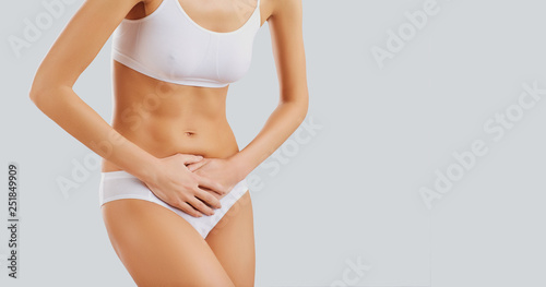 Woman in underwear holding her belly. 