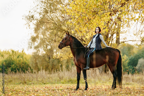 Beautiful girl riding a horse on autumn field