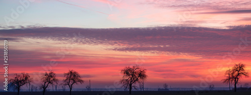  Sunrise sky above the village Gostyn in Greater Poland. Incredible natural colors . Red, orange, purple, dark blue. photo