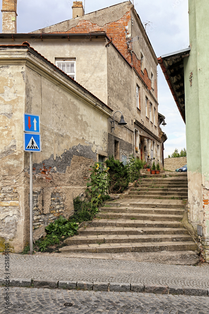 Narrow street with the stairs by the broken facade house