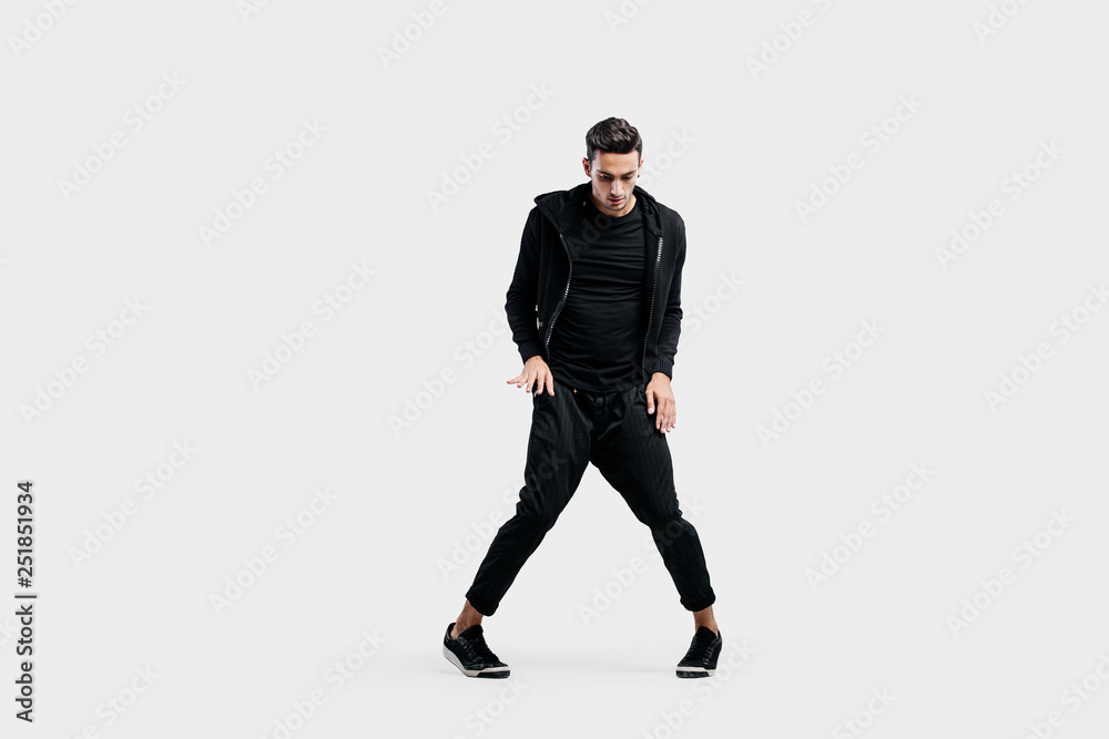 Handsome young man wearing a black sweatshirt and black pants is dancing breakdance Handsome young man wearing a black sweatshirt and black pants is dancing breakdance