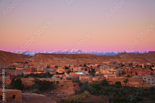 Beautiful sunrise over the snow covered Atlas mountains and a city near Ait Ben Haddou fort in Morocco, Africa