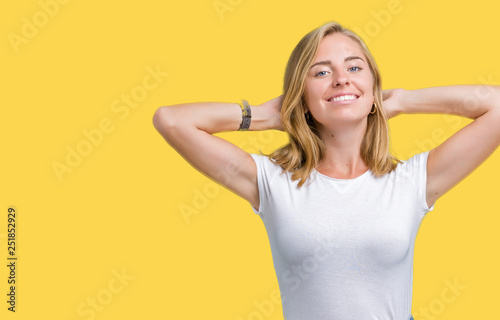 Beautiful young woman wearing casual white t-shirt over isolated background Relaxing and stretching with arms and hands behind head and neck, smiling happy