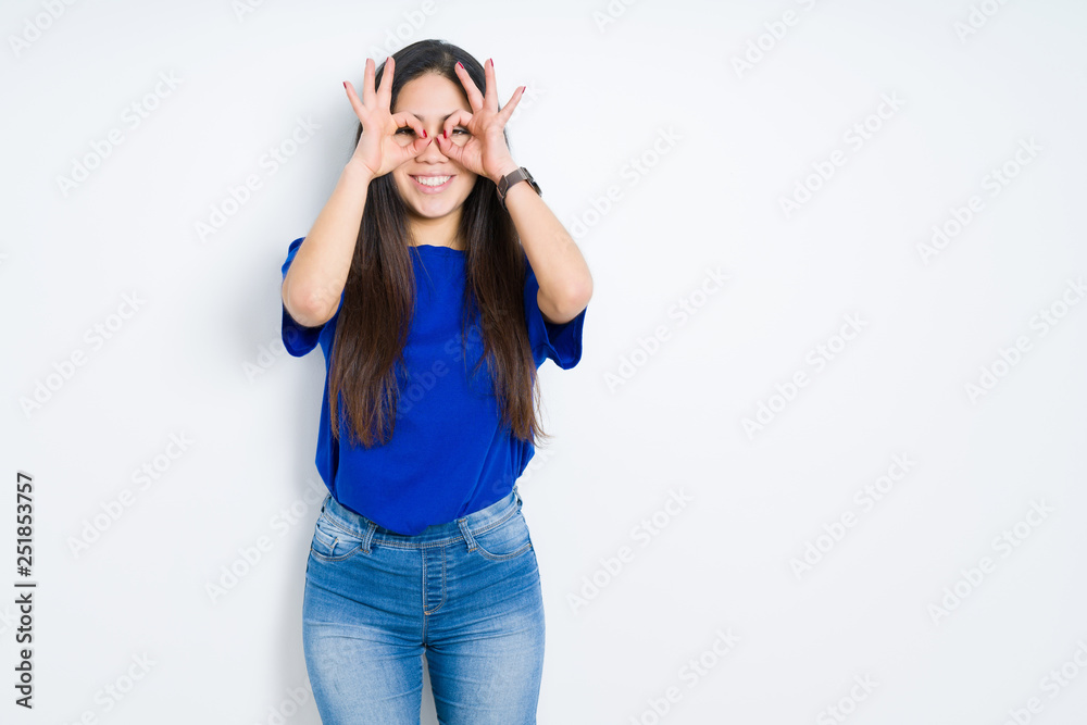 Beautiful brunette woman over isolated background doing ok gesture like binoculars sticking tongue out, eyes looking through fingers. Crazy expression. Beautiful brunette woman over isolated background doing ok gesture like binoculars sticking tongue out, eyes looking through fingers. Crazy expression.