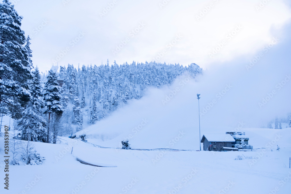 Ski slope in Finland, Lapland. On the mountain running snow machine, snow generator.