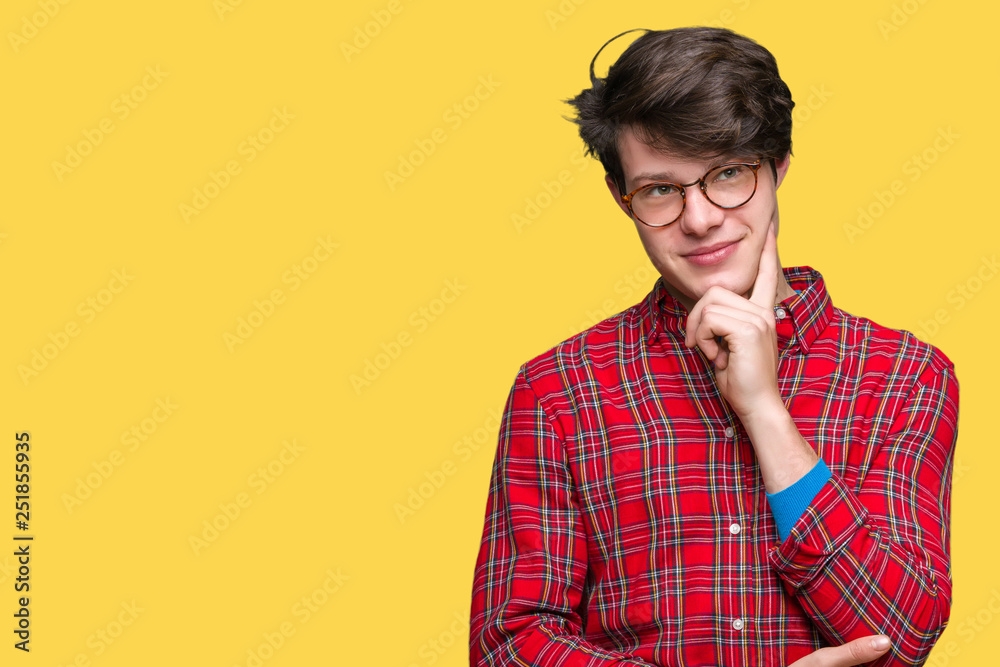 Young handsome man wearing glasses over isolated background with hand on chin thinking about question, pensive expression. Smiling with thoughtful face. Doubt concept. Young handsome man wearing glasses over isolated background with hand on chin thinking about question, pensive expression. Smiling with thoughtful face. Doubt concept.