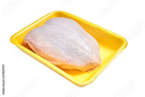 uncooked chicken breast with skin in a yellow plastic container, isolated on white background