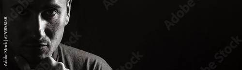 portrait of a guy on a black background in low key