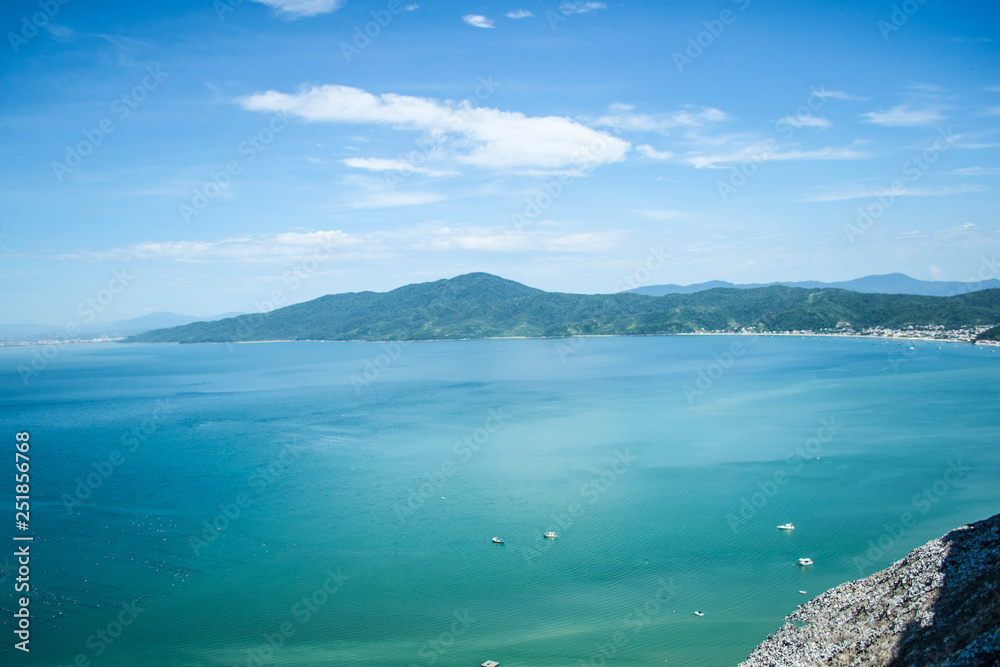 Beautiful landscapes of the coasts of Brazil, with a beautiful blue sky and crystalline waters, accompanied by rocks and green trees
