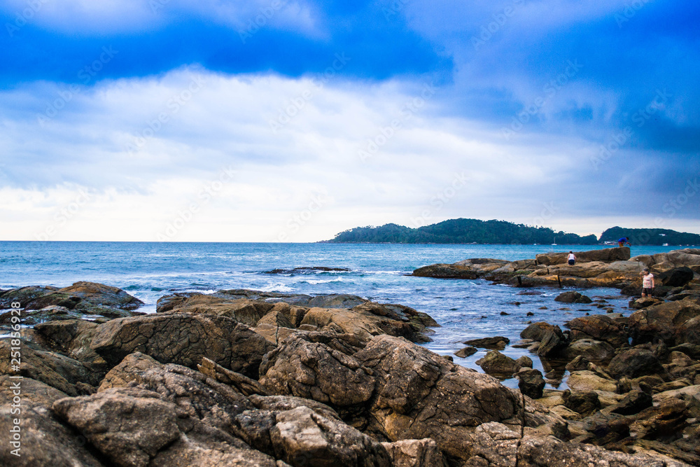Beautiful landscapes of the coasts of Brazil, with a beautiful blue sky and crystalline waters, accompanied by rocks and green trees