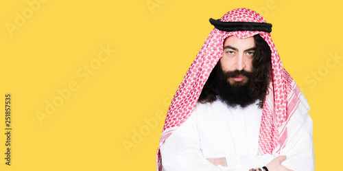 Quadro su tela Arabian business man with long hair wearing traditional keffiyeh scarf skeptic and nervous, disapproving expression on face with crossed arms