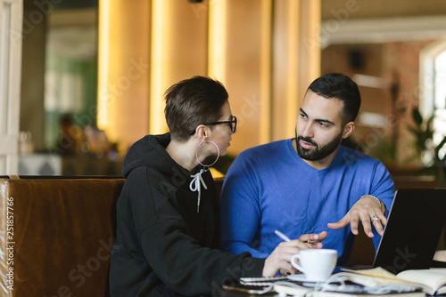 Positive handsome male cooperating with female colleague gesturing during conversation