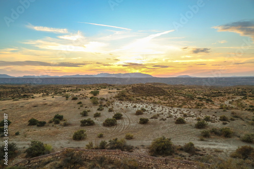 all colours colorful orange yellow red blue sunset in the desert grassland steppe 