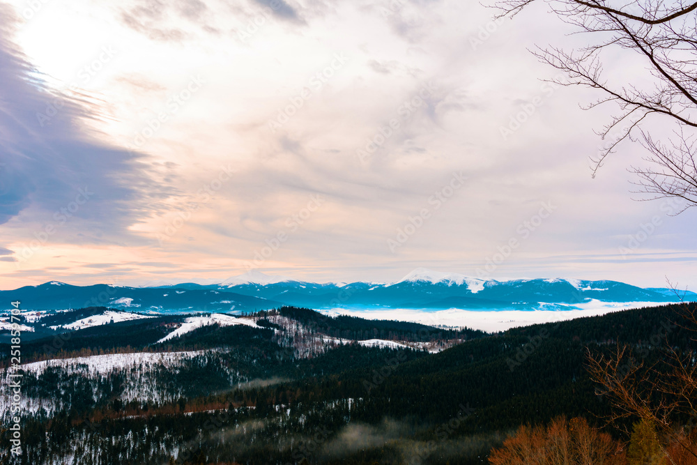 Amazing landscape from the observation deck of one of the Carpathian resorts of the cloudy sky and the snowy mountains