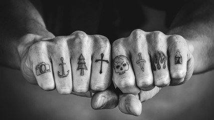 Close up of tattoos on fingers and knuckles.