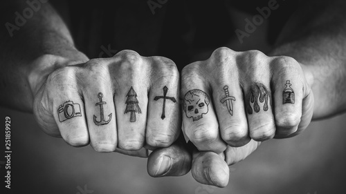 Close up of tattoos on fingers and knuckles.