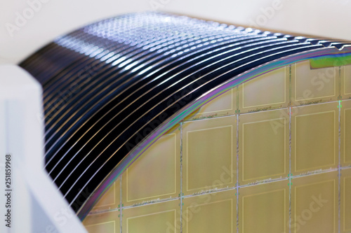 Foto Silicon Wafers in white plastic holder box on a table- A wafer is a thin slice of semiconductor material, such as a crystalline silicon, used in electronics for the fabrication of integrated circuits