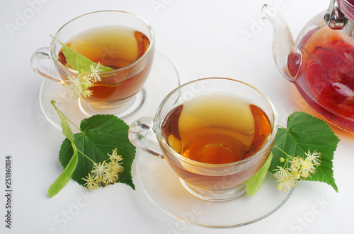  Tea with linden flowers. Two cups of tea and linden flowers and leaves