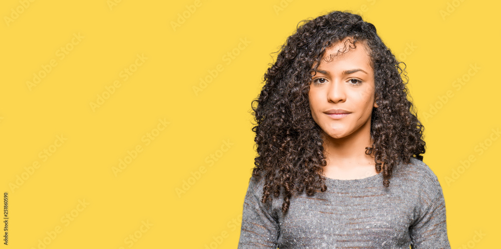 Young beautiful woman with curly hair wearing grey sweater Hands together and fingers crossed smiling relaxed and cheerful. Success and optimistic Young beautiful woman with curly hair wearing grey sweater Hands together and fingers crossed smiling relaxed and cheerful. Success and optimistic