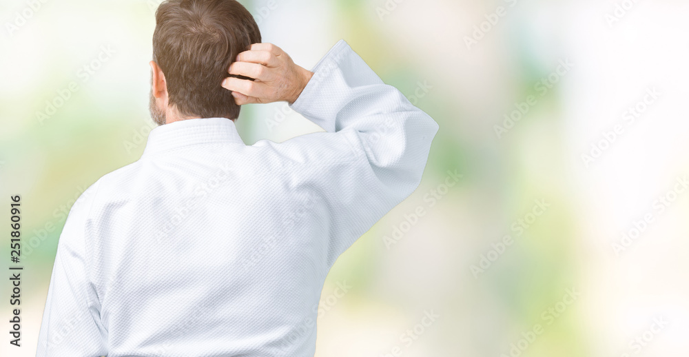 Handsome middle age senior man wearing kimono uniform over isolated background Backwards thinking about doubt with hand on head Handsome middle age senior man wearing kimono uniform over isolated background Backwards thinking about doubt with hand on head