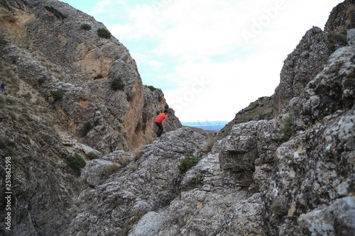 man in gap of rocks on top of the mountain